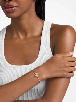 Bracelet en cordon avec logo doré à pierres pavées